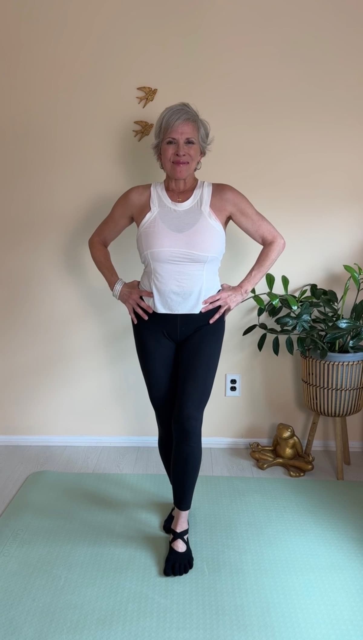 Christine Cernera demonstrating a tandem stance balance exercise, standing confidently with hands on hips